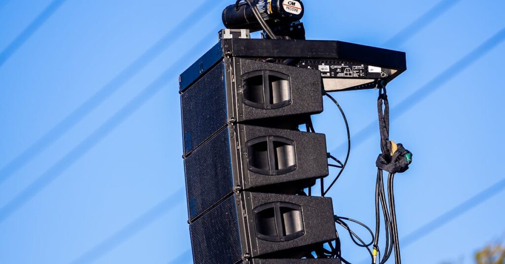 Large line array speakers suspended outdoors for a concert event.